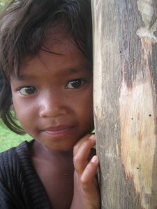 Girl peeking around a tree